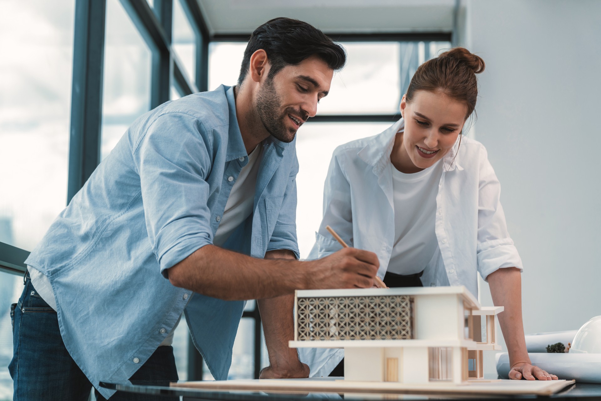 Smart architect engineer team working together to measure house model. Tracery.